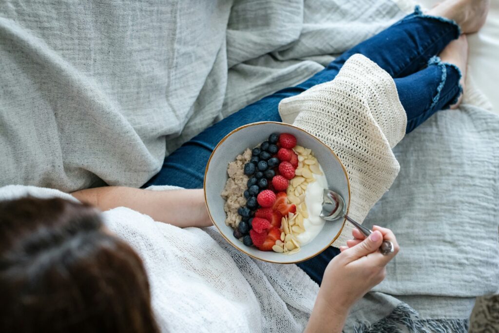 woman eating bowl of yogurt with berries