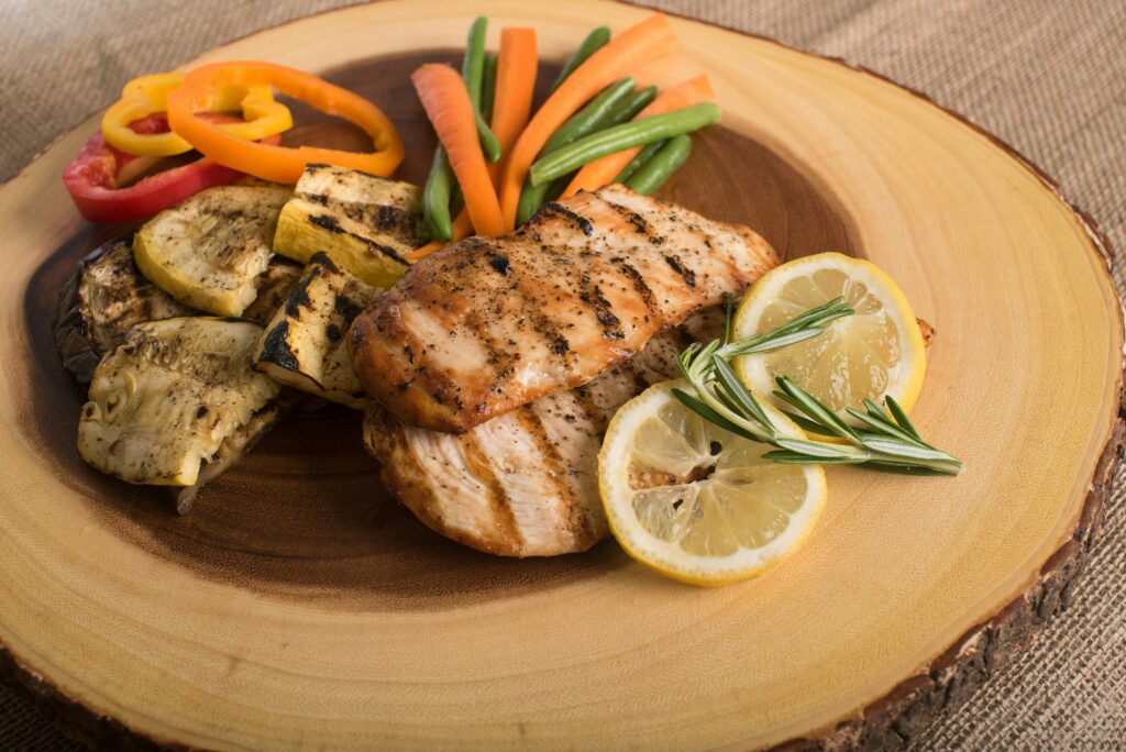 grilled chicken dish with carrots peppers and lemon slices